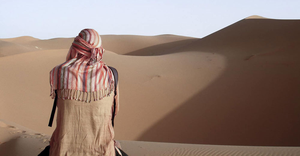 Digitaler Nomade in Wüste - Symbolisch mit Kopftuch